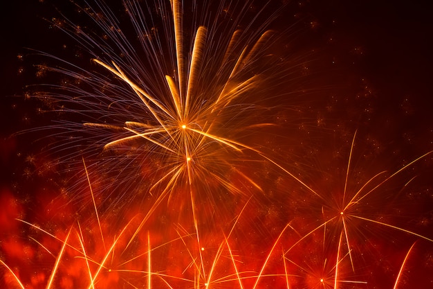 Bellos fuegos artificiales naranjas se exhiben en lo urbano para celebrar en la noche oscura