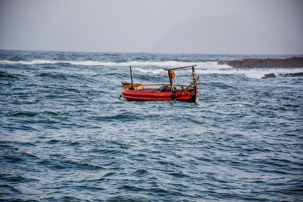 Belo barco vermelho em mar aberto.