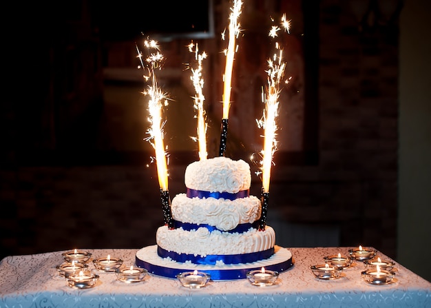 Belo bolo de casamento de três camadas com fogos de artifício