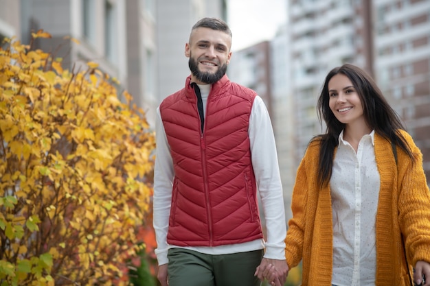 Belo casal alegre estando de bom humor enquanto caminham juntos