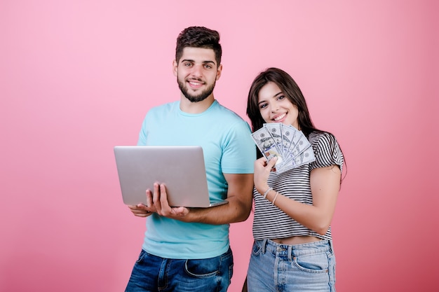 Belo casal jovem rico homem e mulher com notas de laptop e dólar