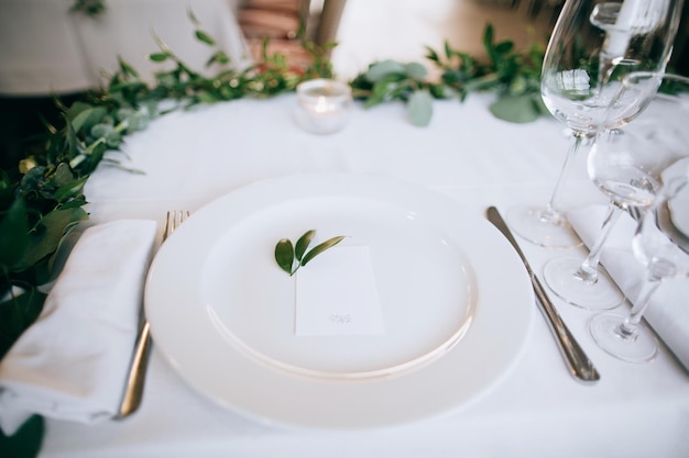 Belo cenário de mesa de casamento Pratos brancos na toalha de mesa branca