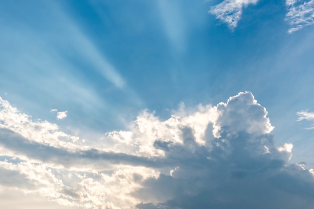 Belo céu azul com nuvens e raios de sol raios solares