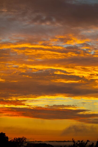 Belo céu idílico ao amanhecer com fortes cores amarelas e laranjas