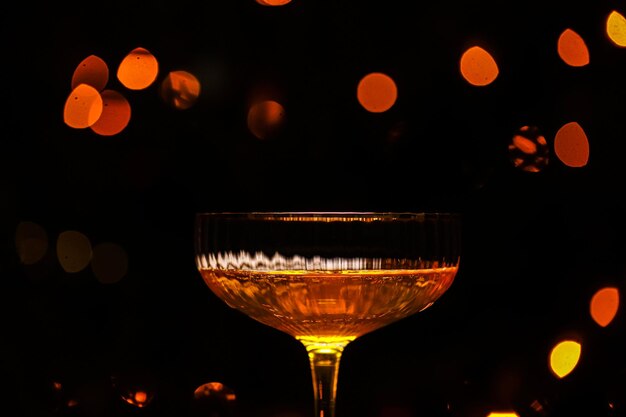 Belo copo de champanhe contra luzes bokeh fundo com uma árvore de Natal decorada feliz