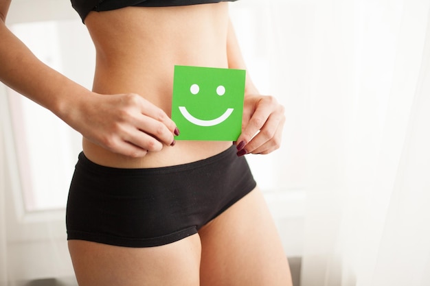 Belo corpo feminino de calcinha com cartão de sorriso