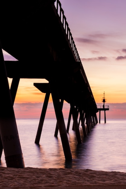 Foto belo despertar do céu com poucas nuvens e mar próximo a uma passarela