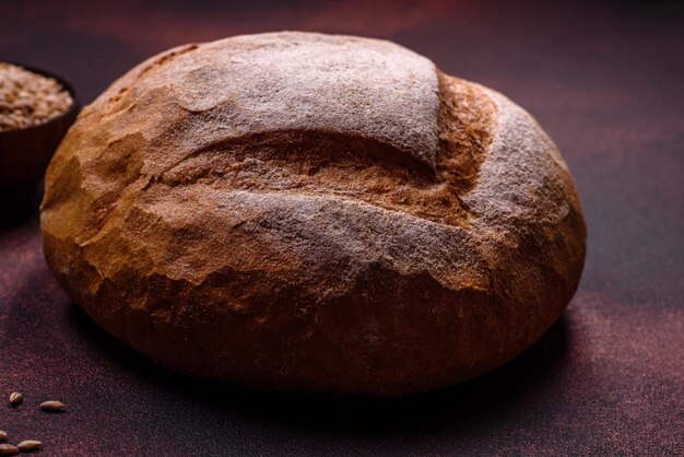 Belo e delicioso pão branco redondo recém-assado em um fundo escuro de concreto