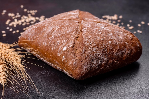 Belo e saboroso pão marrom em forma de quadrado em um fundo escuro de concreto Assando pão em casa