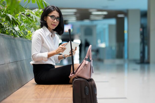 Belo empresário com tablet no saguão do aeroporto