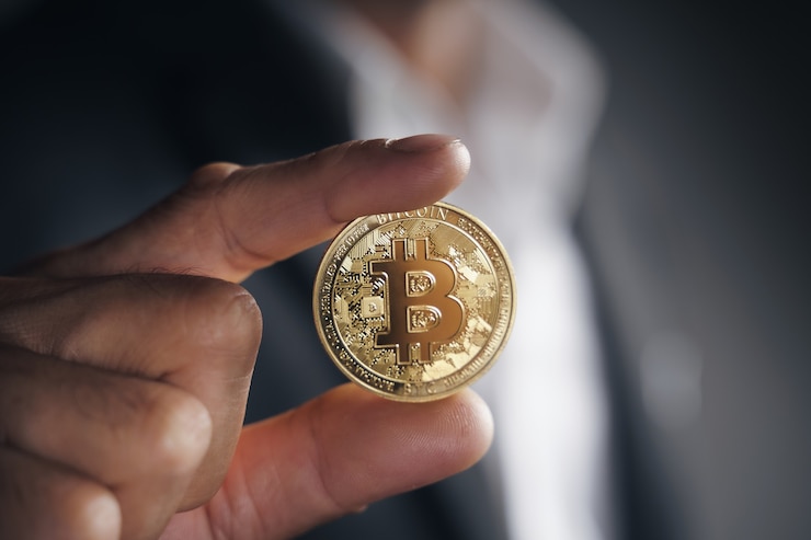 Foto belo empresário investidor em terno preto segurando um bitcoin dourado sobre fundo escuro, negociação, criptomoeda, moeda virtual digital, finanças alternativas e conceito de investimento.