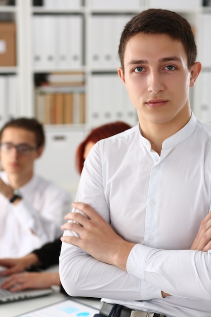 Belo empresário sorridente no local de trabalho com os colegas