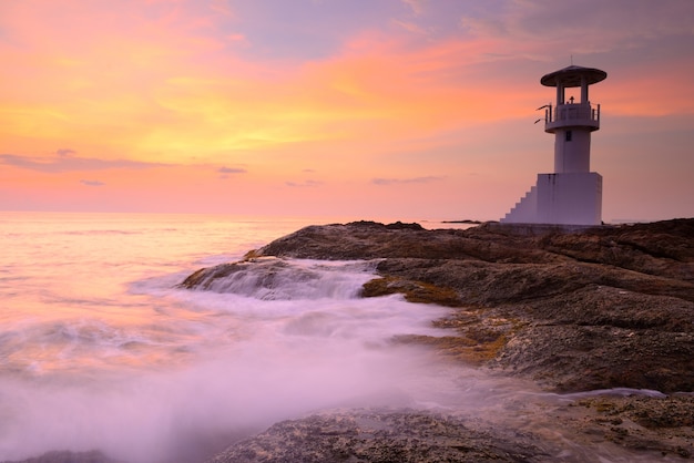 Foto belo farol ao pôr do sol do mar