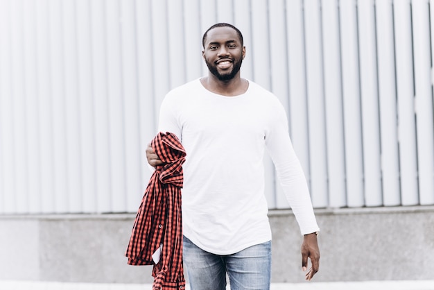 Belo homem afro-americano com roupas casuais na cidade moderna