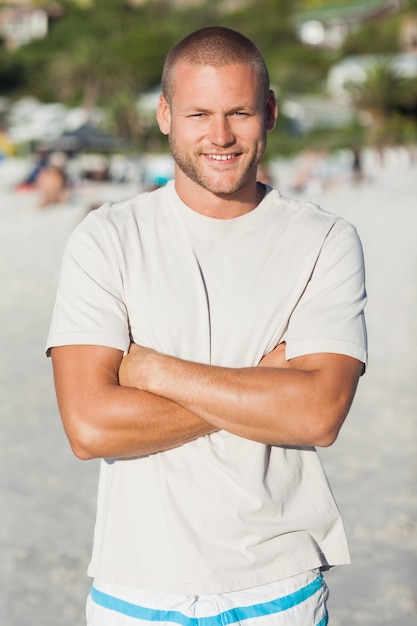 Belo homem feliz em maiô e tshrt posando