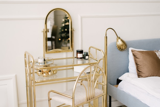 Foto belo interior branco. paredes clássicas da sala com estuque, vidro penteadeira de cadeira dourada com espelho, decorada com decoração, foco seletivo
