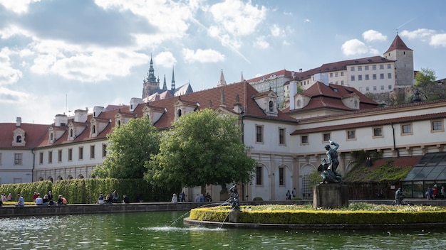 Belo jardim histórico com piscina fonte e castelo elevando-se acima dela Praga República Checa