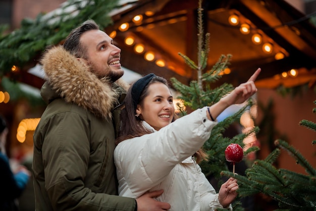 Belo jovem casal tradicional feliz no mercado de natal Férias de inverno Férias na Europa Ano Novo