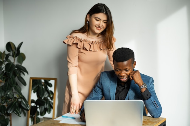 Foto belo jovem e mulher trabalhando no escritório com laptop