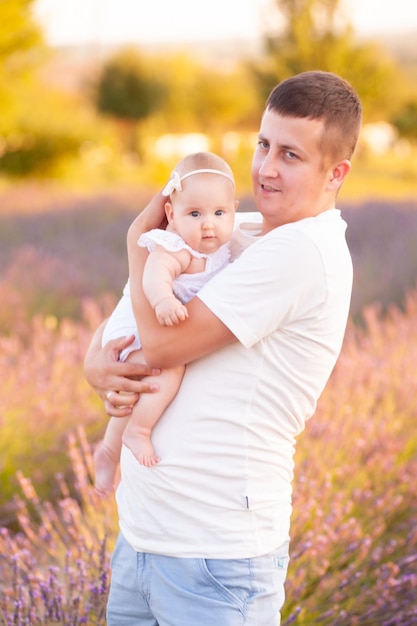 Belo jovem pai com bebê no campo de lavanda