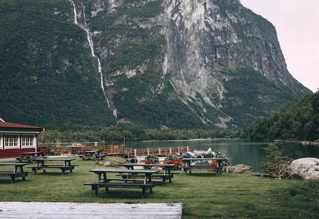 belo lago de montanha com mesas de madeira e bancos de piquenique nas montanhas da Noruega