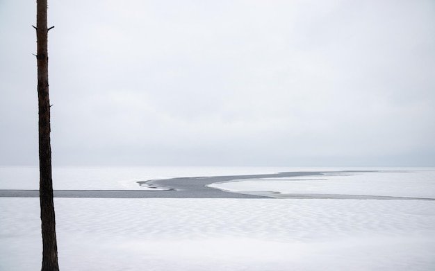 Belo lago enorme em um dia nublado A superfície do lago com uma rachadura na águaPeríodo de inverno