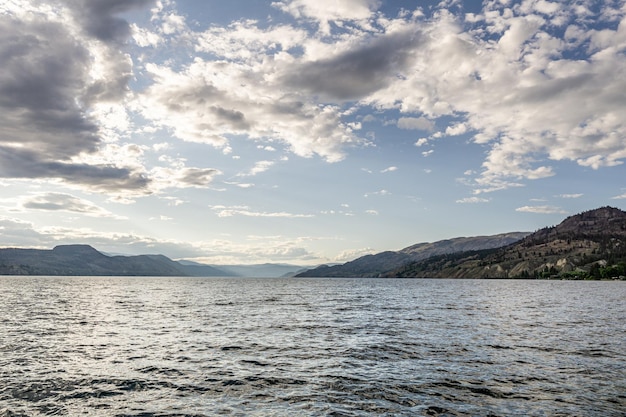 Belo lago Okanagan com céu azul e nuvens brancas dia de verão