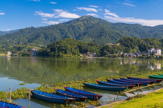 Belo lago verde phewa com barcos e montanhas verdes na cidade de pokhara, no nepal, durante as monções