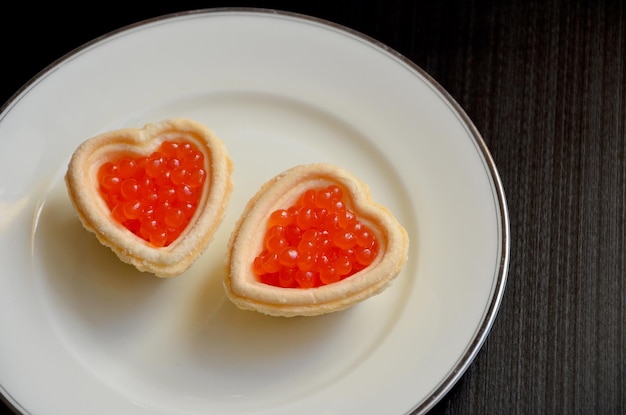 Belo lanche original duas tortinhas com caviar em um prato
