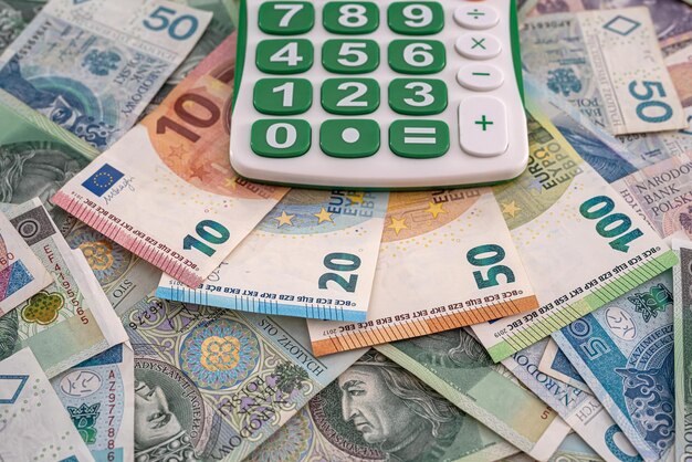 Belo layout da vista superior do euro e polonês novas notas de zlotys e calculadora com teclado bonito. conceito de negócios