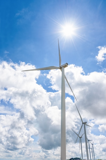 Belo moinho de vento sob o sol no céu azul e fundo de nuvens brancas, fonte de energia elétrica ecológica de energia limpa ajuda a reduzir o aquecimento global