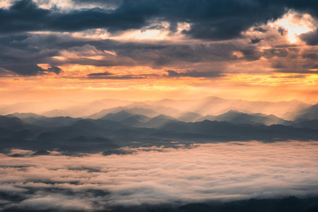 Belo nascer do sol dramático brilhando na montanha com neblina no vale no parque nacional Doi Dam Wiang Haeng Chiang Mai Tailândia