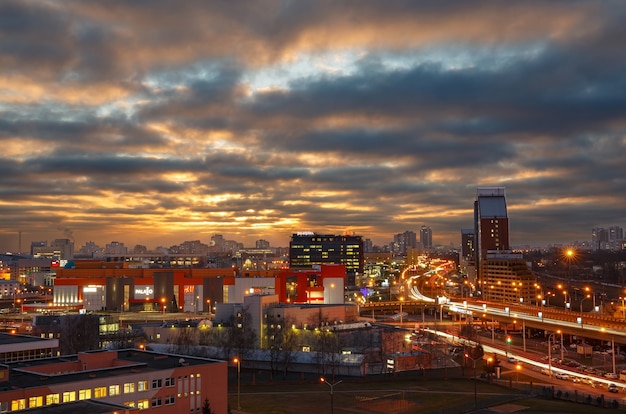 Belo nascer do sol e as luzes da cidade à noite.