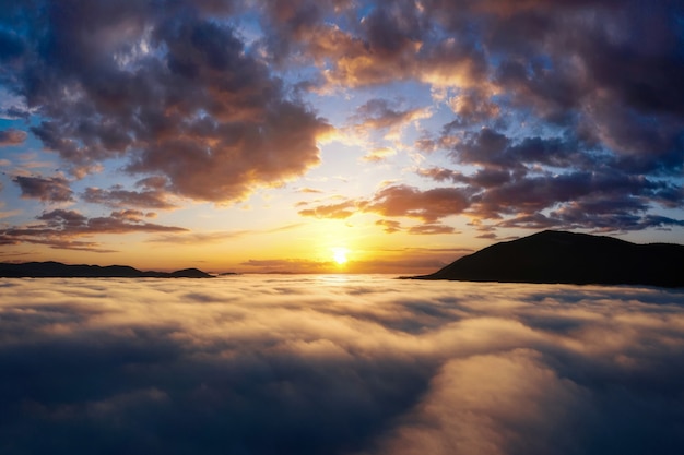 Belo nascer do sol nas montanhas. Paisagem cênica com céu dramático sobre nuvens espessas no vale da montanha. Vista aérea do drone.