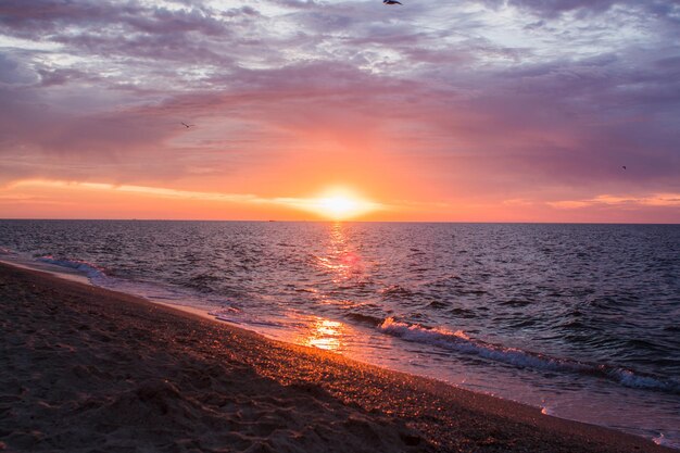 Belo nascer do sol no mar com nuvens