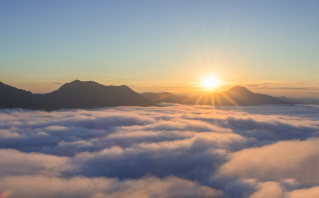 Belo nascer do sol sobre a montanha com nevoeiro pela manhã