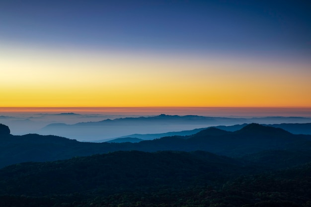 Belo nascer do sol sobre a montanha com nevoeiro pela manhã