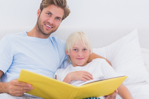 Belo pai lendo uma história para seu filho