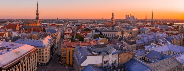 Belo panorama aéreo do centro de Riga e a ponte Vansu sobre o rio Daugava durante o pôr do sol incrível. Vista da cidade iluminada de Riga, capital da Letônia.