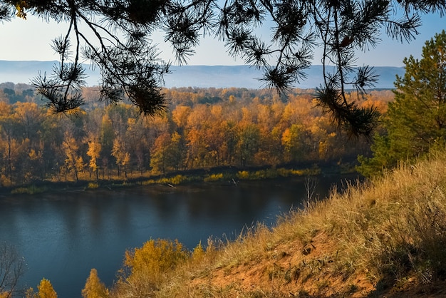 Belo panorama da floresta de outono, do outro lado do rio nas colinas de montanha. Vale incrível entre as encostas das montanhas.