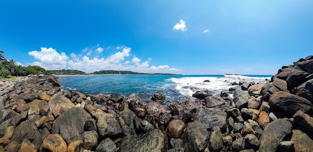 Foto belo panorama da praia ensolarada praia exótica do oceano com fundo tropical de rochas