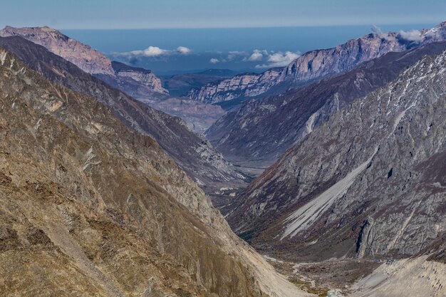 Belo panorama de altas montanhas rochosas contra o céu azul e nuvens