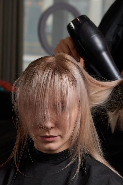 Belo penteado de jovem depois de tingir o cabelo e fazer destaques no salão de cabeleireiro