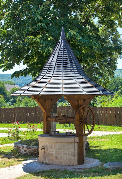 Belo poço com telhado afiado no parque