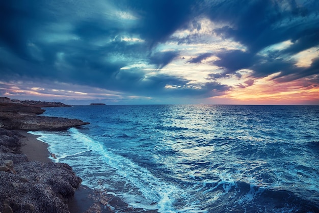 Belo pôr do sol colorido no mar com nuvens dramáticas e céu colorido. Fundo de viagens naturais ao ar livre do mundo da beleza