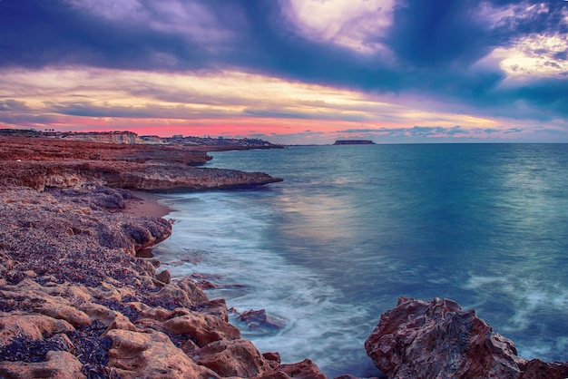 Belo pôr do sol colorido no mar com nuvens dramáticas e céu colorido. Fundo de viagens naturais ao ar livre do mundo da beleza