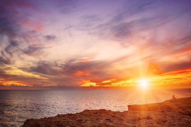 Belo pôr do sol colorido no mar com nuvens dramáticas e o sol brilhando. Fundo de viagens naturais ao ar livre do mundo da beleza