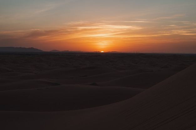 Belo pôr do sol com muitas dunas no deserto do Saara