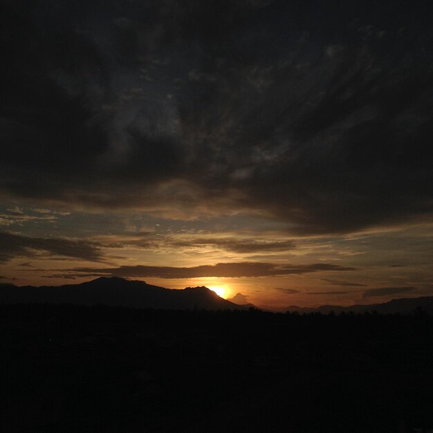 belo pôr do sol com uma silhueta de montanha