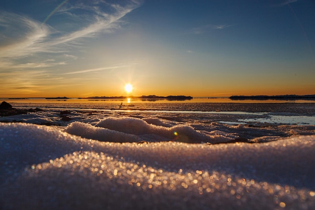 Belo pôr do sol de inverno à beira-mar com iceberg